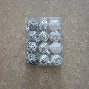 Julkulor - Snygga julgranskulor i silver och vitt, 12-pack. Tillverkade i plast, Ø 3,5 cm. Perfekt för att dekorera granen med en elegant och modern känsla. Oöppnad förpackning, inga synliga skador eller slitage.