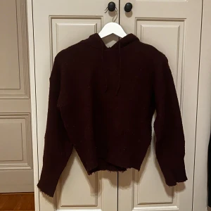 Mörkbrun hoodie från Gina Tricot - Mysig mörkbrun hoodie från Gina Tricot med huva och långa ärmar. Tröjan är stickad och har en loose passform med råa kanter vid ärmslut och nederkant. Perfekt för höst och vinter när du vill ha något skönt och chill.