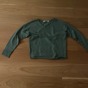 Grön stickad v-ringad tröja ONLY - Mysig grön stickad tröja från ONLY i storlek S. Tröjan har v-ringad hals och långa ärmar med ribbade muddar. Perfekt för dig som gillar enkel och stilren design med en chill vibe.