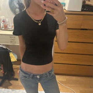 Svart croppad topp från FB Sister - Säljer en svart croppad topp från FB Sister i storlek M men är ganska kort så skulle säga mellan S - XS.Toppen är ribbad med korta ärmar och har en snygg öppen rygg med knyt-detalj baktill. Pris kan diskuteras! Går inte under 40kr❤️