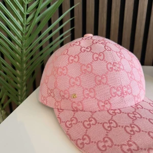 Rosa keps från Gucci med GG-mönster - Säljer en snygg rosa keps från Gucci med ikoniskt GG-mönster över hela kepsen. Justerbar rem bak i rosa läder och klassisk böjd skärm. Perfekt accessoar för dig som vill sticka ut med lyxig streetstyle.