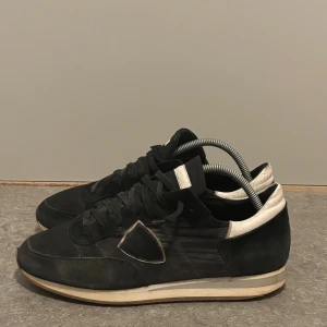  Philippe Model trainers - Svarta sneakers från Philippe Model med vit detalj på hälen och tungan. Skorna har en rund tå, snörning och platt sula. Väldigt sköna och nice just nu till vintern. Hör gärna av dig om du har funderingar och pris eller annart, svarar oftast snabbt