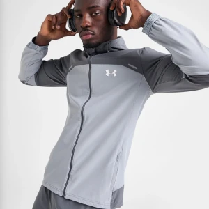 Grå vindjacka från Under Armour - Snygg grå vindjacka från Under Armour med två olika grå nyanser och logga på bröstet. Jackan har hel dragkedja, hög krage och elastiska muddar med tryck. Perfekt för träning och aktiva dagar.