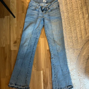 Bootcut jeans från 157 i ljusblå denim - Snygga ljusblå bootcut jeans från 157 med klassisk femficksdesign och råa, fransiga kanter vid bensluten. Jeansen har en normal passform och är tillverkade i mjuk denim. Perfekta för dig som gillar retrovibbar och avslappnad stil.