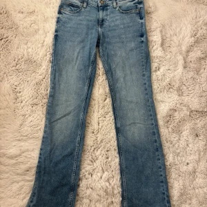 Ljusblå bootcut jeans från Lee - Snygga ljusblå jeans från Lee med klassisk femficksdesign och bootcut-ben. Jeansen har Lee-logga på bakfickan och läderpatch i midjan. Tillverkade i slitstarkt denim med normal passform och dragkedja framtill. Lågmidjade och poplulära! Ganska stretchiga och därför bekväma. Endast använda en gång men var förstora. Köpta för 1099kr. 