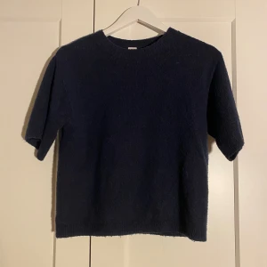 Mörkblå stickad tröja från Lindex - En enkel och snygg mörkblå stickad tröja från Lindex med rund hals och korta ärmar. Perfekt för dig som gillar en clean look och vill ha något mjukt och skönt! Den är stretchiga och passar mig som 14 åring (som i vanliga fall har stl S)