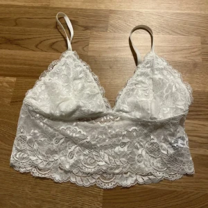 Vit spets bralette  - Vit bygellös spets bralette i strl M. Mycket bra skick! Använd en gång!