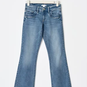 Blå bootcut jeans med ljus tvätt - Snygga blå jeans med bootcut passform och ljus tvätt. Har sprätat upp de längst ner för att få de längre.