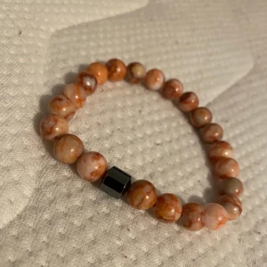 Brunt pärlarmband med marmorerade kulor - -