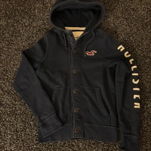 Hollister cardigan (sjukt eftertraktad) - Säljer nu denna eftertraktade cardiganen ifrån Hollister. Skick 8/10. Rikigt snygg och passar perfekt nu till hösten! Obs kan gå ner i pris vid snabb och smiddig affär!