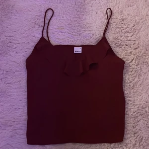 Vinröd linnetopp från Gina Tricot - Säljer en vinröd linnetopp från Gina Tricot i storlek XS. Toppen har smala axelband och en snygg volangdetalj framtill. Materialet är mjukt och lätt, perfekt för varma dagar. Toppen är oanvänd, så den är i nytt skick! Kontakta gärna vid intresse, vid köp välj gärna Instabox eller Postnord, blir lättare att frakta för mig! 