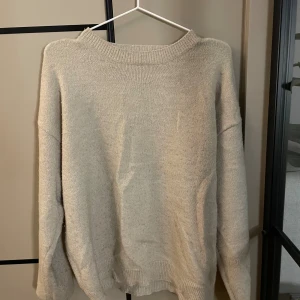 Beige stickad tröja - En enkel och stilren beige stickad tröja med rund hals och ribbade muddar vid ärmslut och nederkant. Storlek 164, men passar mig som normaltvis har S. Hyfsat knopprig därav priset.
