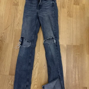 Svarta/Grå Jeans  - Snygga jeans med hål och slits. Använts ett par gånger och har tecken på användning. Höga i midjan och tajta i passform.