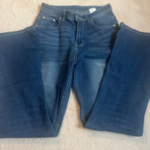 Blå jeans med broderade fickor, S - Utsvängda byxor med detaljer på fickorna. Inga hål och har använt 2 ggr. Jag köpte dom på vinted för 400 kr. Lappen som det står var dom är ifrån är borttagen.