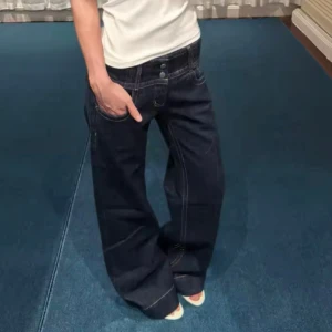 Mörkblå wide jeans med låg midja - Säljer ett par mörkblå jeans med breda ben och låg midja. Jeansen har tydliga vita sömmar, klassiska fem fickor och dubbla knappar fram. Materialet är jeans och passformen är loose med en riktigt chill vibe.
