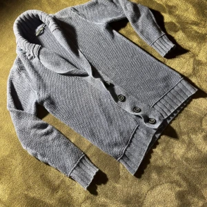 Blå stickad kofta❄️ - Mysig blå stickad kofta med bred krage och fyra stora knappar framtill. Koftan har ribbade muddar och nederkant, samt långärmad passform. Perfekt för lager-på-lager och chill dagar.