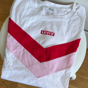 Levi's vit t-shirt  - Snygg vit t-shirt från Levi's med korta ärmar. Klassisk rund hals och Levi's logga framtill. Endast använd ett fåtal gånger. 