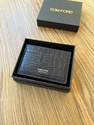 Tom Ford korthållare | crocodile leather - Säljer en Tom Ford-korthållare i mycket fint skick. Tillverkad i exklusivt crocodile leather i mörkblå färg.  Korthållaren kommer med originalbox samt originalpåse, som ingår i köpet.  Skicka gärna PM vid intresse eller om du vill ha fler bilder/detaljer.