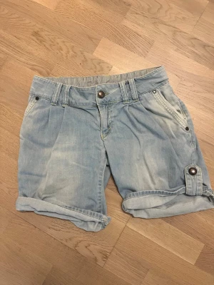 Jeansshorts VILA storlek S - Säljer ett par ljusblå denimshorts med uppvikta benslut och snygga knappdetaljer. Från VILA i storlek S