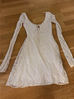 Vit spetsklänning med snörning - Jag säljer denna fina vita spetsklänningen från bershka som är öppen i ryggen och snörning på framsidan på överkroppen💕 den är i jättebra skick och använd 1 gång, den är i storlek xs. Skriv vid minsta fundering🤗