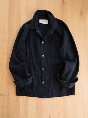 A Day’s March HBT Chore Jacket, size S - Stilren svart overshirt i kraftigt bomullstyg från a days march. Klassisk krage, tre utanpåliggande fickor och knäppning med fyra stora knappar framtill. Perfekt lager-på-lager-plagg med avslappnad passform och uppvikta ärmslut.
