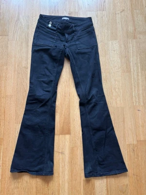 Svarta low waist bootcut jeans med fickor❣️ - SER BLÅ UT PÅ EN DEL BILDER MEN DET ÄR PGA LJUSET KAN SICKA NYA‼️ Säljer ett par svarta low waist bootcut jeans med fickor framtill och utsvängda ben. Jeansen har låg midja och stängs med två knappar och dragkedja. Från Gina 14+ i storlek S❣️ använda några gånger men inte något slitna