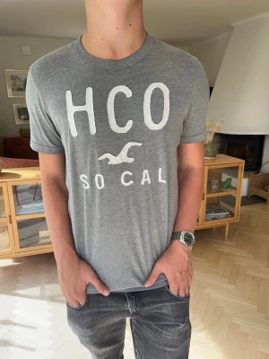 Hollister vintage T-shirt herr med tryck grå vit - Hollister HCO SoCal T-shirt i grått med vitt broderat/tryckt motiv. Storlek M. Stilren och lättmatchad modell. Bra skick.  #Hollister #HCO #SoCal #Tshirt #Herrkläder #Casual #Streetwear #Preppy #SizeM #M