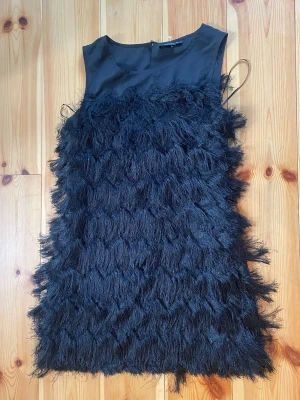 Svart klänning med fransdetaljer - Cool svart kortklänning med fransar från esmara! Aldrig använt denna men köpt second hand. Inga defekter eller liknande!