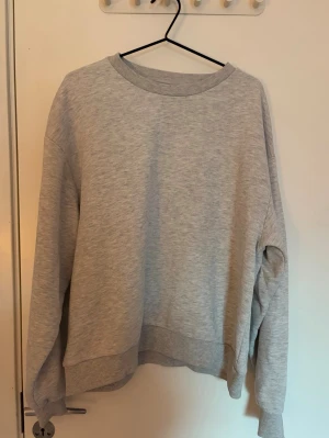 Ljusgrå oversized sweatshirt Gina Tricot  - En enkel och stilren ljusgrå sweatshirt i oversized modell från Gina Tricot. Tröjan har rund halsringning, långa ärmar och ribbade muddar vid ärmslut och nederkant. Perfekt för en avslappnad och casual look🩶