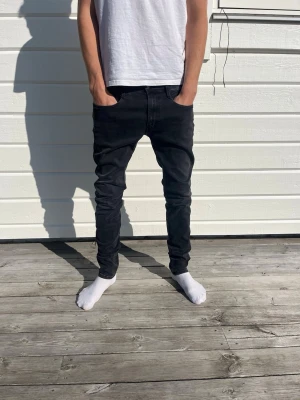 Replay Svarta slim fit jeans herr 32/34 - Säljer ett par svarta slim fit jeans med klassisk femficksmodell och normal midja. Jeansen har smal passform hela vägen ner och är tillverkade i stretchigt denimtyg för extra komfort. Perfekta för en clean och modern look. Storlek: 32/34. Använda fåtal gånger, väldigt bra skick!