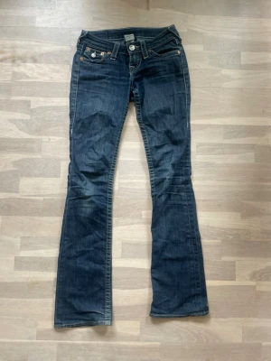 Mörkblå true religion jeans - Säljer min Lågmidjade true religion jeans med glitter på fickorna säljer dessa då dom inte längre passar, jag köpte jeansen för 1200, dom har midjemått 36 och innerbenslängd 86😋.