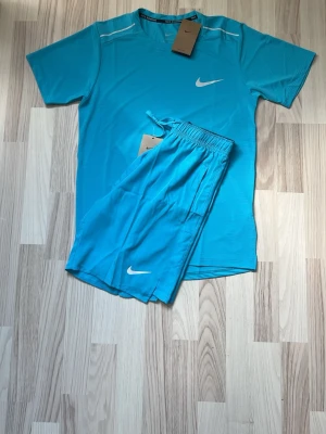Blått Nike Miller set - Hej, jag säljer nu ett shysst träningsset från Nike med t-shirt och shorts. Såklart är den ny med inga defekter. Tillkommer bag. Hör av er om frågor och prisfunderingar!😀