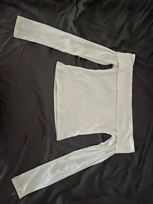Vit ribbad offshoulder topp - Trendig vit offshoulder topp med långa ärmar och ribbad struktur. Passar XS/S och säljer då jag växt ur den. Pris kan diskuteras 🩷