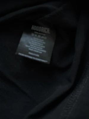 Svart HOODRICH t-shirt med tryck pojkstorlek xl - Snygg svart t-shirt från HOODRICH i storlek XL, med stort vitt tryck över bröstet och en cool detalj i rött och grått på sidan. Klassisk rund hals och korta ärmar. Tillverkad i mjuk bomull som känns skön mot huden.