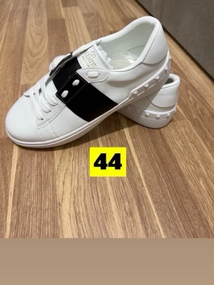 Vita sneakers med svart band - Snygga vita sneakers från Valentino Garavani. Helt nya, pris kan diskuteras så jag tar gärna emot prisförslag.