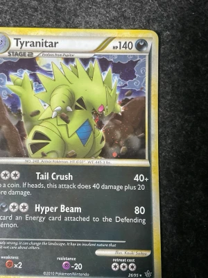 Två Tyranitar Pokémonkort - Säljer två olika Tyranitar Pokémonkort med coola illustrationer. Båda korten har gul ram och visar Tyranitar i olika poser. Kortens text och attacker är på engelska och de har detaljerade effekter och stats. Perfekt för samlare eller Pokémonfans!
