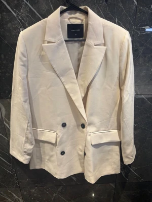 Beige dubbelknäppt kavaj - Jättefin beige kavaj från LCW Vision i storlek 38. Helt oanvänd och i nyskick. Stilren dubbelknäppt modell med snygg passform som passar både till vardags och finare tillfällen.  Kan självklart skicka fler bilder eller mått vid intresse! 🤍
