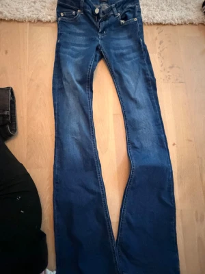 Blå bootcut jeans från NLY Jeans - Snygga blå bootcut jeans från NLY Jeans med klassisk femficksmodell och kontrastsömmar. Jeansen har normal midja och är tillverkade i ett mjukt denimtyg som sitter skönt. Perfekta för dig som gillar en tidlös och avslappnad stil.