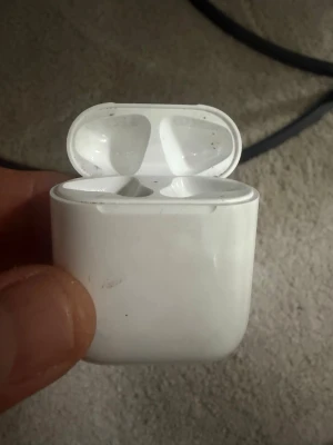 Trådlösa vita  laddningsetui - Säljer ett par trådlösa vita hörlurar från Apple med tillhörande laddningsetui. Smidig och kompakt design som enkelt får plats i fickan. Perfekt för musik, poddar och samtal på språng. Laddningsetuiet har magnetlock och LED-indikator.