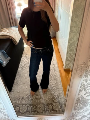 Mörkblå bootcut jeans från Aband Jeans - Säljer ett par ultra low waist mörkblå bootcut jeans från Abrand. Väldigt fin färg och sitter snyggt på. Dock lite slitna där nere vid fötterna men inget som syns tydligt, säljer då jag inte använder dem.