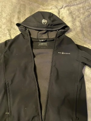 Sail racing vindjacka - Svart vindjacka från sail racing. Perfekt nu till hösten. Den är i väldigt gott skick förrutom att jag tycker den är lite liten i storlek annars är den väldigt skön.