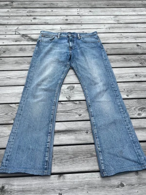 Levis 527 jeans-bootcut - Obs. Mycket bra skick! Ett par ljusblå jeans från levis i modell 527 (bootcut).  Utsvängda ben och lite blekna åt det ljusare hållet på framsidan. Riktigt schysst tvätt/färg. Väldigt bra skick då jag endast använt dessa några gånger.                                                    Mått: Midja=44cm Längd=100cm Benöppning=22cm.                            Tveka inte att höra av er vid frågor eller behov av fler bilder!