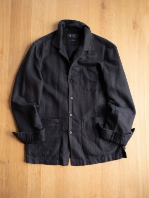 Svart Chore Jacket, size M - Stilren svart overshirt med tre framfickor och knäppning framtill. Overshirten har klassisk krage och raka ärmar. Tillverkad i ett lätt tyg som ger en avslappnad look. Perfekt att bära över en t-shirt för en enkel men snygg stil.