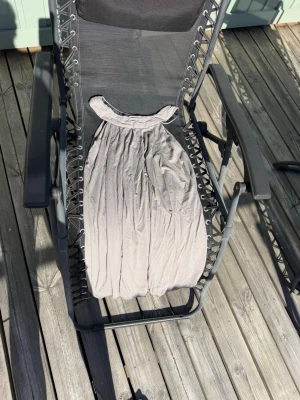 Ljusgrå ärmlös kortklänning - Säljer en enkel och snygg ljusgrå kortklänning med rundad halsringning och ärmlös design. Klänningen har ett mjukt, lätt tyg som faller fint och passar perfekt till varma dagar.