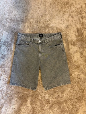 Grå jeansshorts från H&M Relaxed - Snygga grå jeansshorts från H&M i relaxed fit. Klassisk femficksmodell med knappgylf och bälteshällor. Materialet är slitstarkt denim i 100% bomull och färgen har en tvättad look som ger en cool vibe.