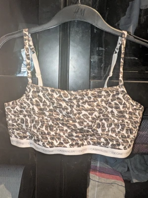 Leopardmönstrad bralette Calvin Klein - Säljer en leopardmönstrad bralette från Calvin Klein med bred resår och logga längst ner. Den har justerbara axelband och är tillverkad i mjuk bomullsblandning. Endast testad 1 gång. Inga synliga fläckar eller defekter. Skapa en bundle för bättre pris