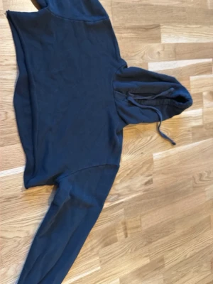 Svart hoodie från NA-KD - En svart hoodie från NA-KD i storlek XS. Hoodien har en klassisk huva med dragsko och långa ärmar. Tillverkad i mjukt sweatshirtmaterial som är perfekt för chill dagar. Enkel och stilren design utan tryck eller detaljer.
