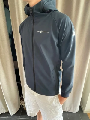 Sail Racing vindjacka - Tja säljer nu en sprillans ny vindjacka från Sail Racing med huva och hel dragkedja framtill. Perfekt till sommaren eller en lite kyligare dag  eller bara en trist regndag. Storlek 172 men passar till 176cm som XS. Hör gärna av er vid minsta lilla fundering!