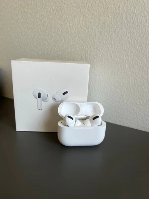 Apple AirPods Pro (1st gen) + originalkartong 🎧 - Säljer ett par Apple AirPods Pro med tillhörande laddningsetui och originalkartong.  • AirPods Pro 1st generation • Modell: A2083 / A2084 • Laddningsetui medföljer • Originalkartong medföljer • Använda och har normala spår av användning • Säljs enligt bilderna  Perfekta som extra hörlurar eller för dig som vill ha AirPods Pro till ett billigare pris.  Kan skicka fler bilder eller information vid intresse 📩