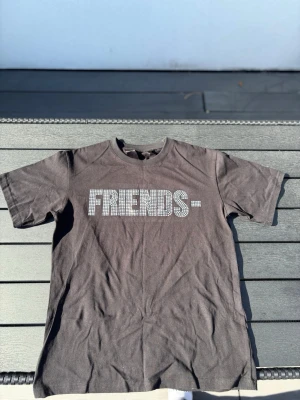 Vlome tshirt - Cool svart t-shirt med texten FRIENDS- i vitt på framsidan och ett stort V i vitt på ryggen, båda i ett prickigt mönster. Klassisk passform och rund halsringning, perfekt till jeans eller shorts.